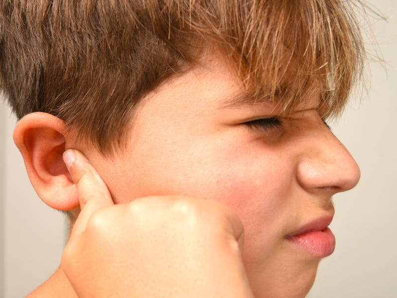 Boy with fingers in ear, too loud