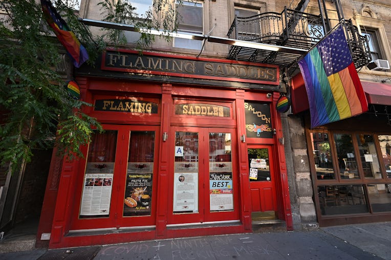 NEW YORK, NEW YORK - JUNE 22: Pride flags hang outside a temporarily closed Flaming Saddles Saloon i...