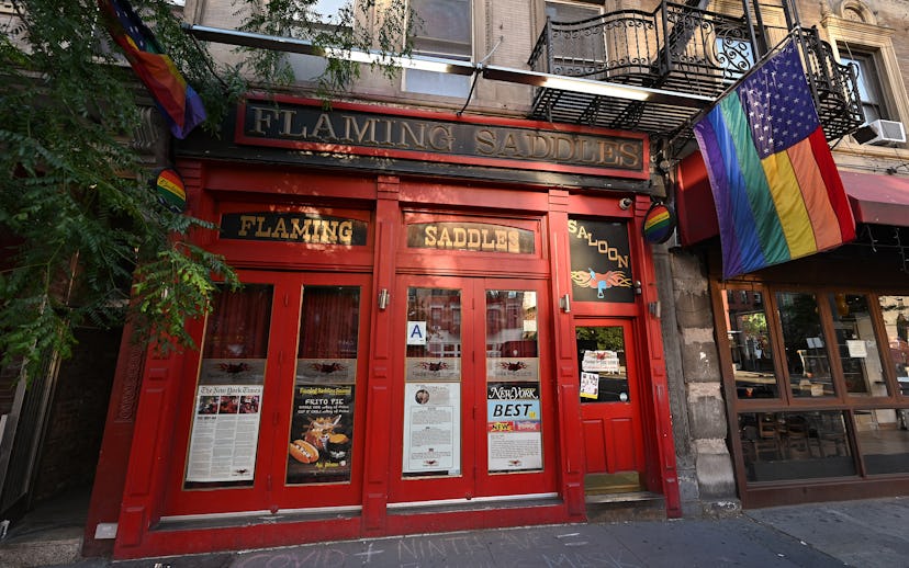 NEW YORK, NEW YORK - JUNE 22: Pride flags hang outside a temporarily closed Flaming Saddles Saloon i...