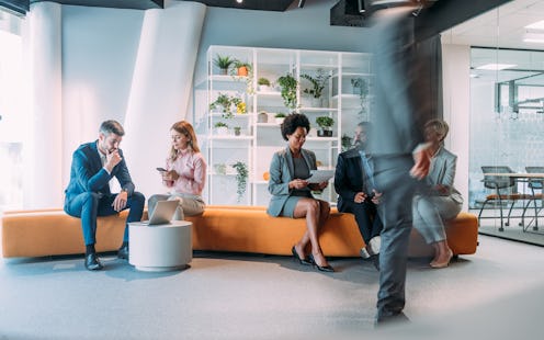Shot of business people having a meeting in modern office. Blurred motion of energetic businesspeopl...