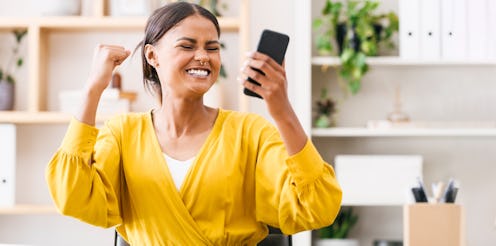 Happy, excited and woman with phone in office, celebrate success, good news text on online discount ...