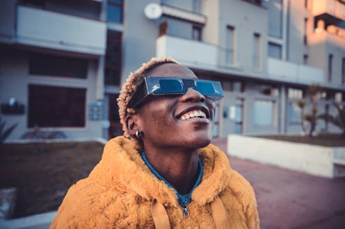 Teenage girl looking at solar eclipse wearing the proper protective eyeglasses