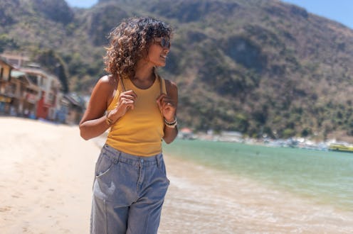 A beautiful woman walks along the seashore, enjoying her vacation and summer day