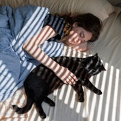 Cat and owner: a morning friendship bonding experience in bed, trust and love