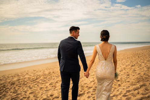 Bride and groom walking through the beach