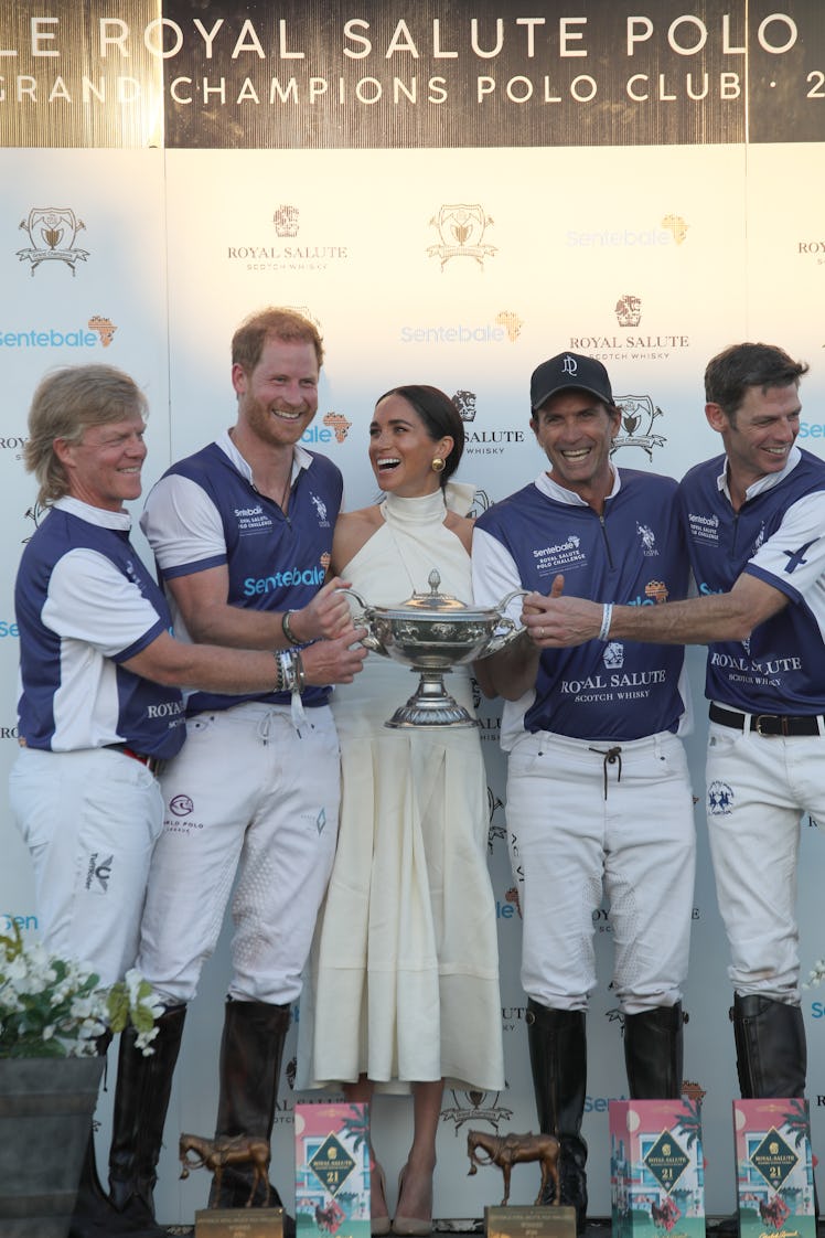 The Duchess of Sussex presents the trophy to her husband, the Duke of Sussex after his team the Roya...