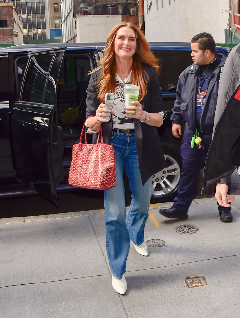 Brooke Shields carries a red Goyard Saint Louis in Midtown on April 04, 2023 in New York City.
