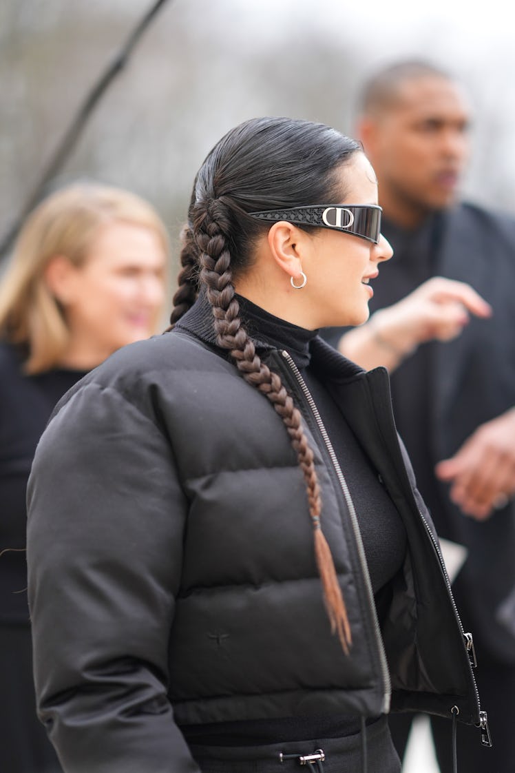 PARIS, FRANCE - FEBRUARY 27: Rosalia wears Dior sunglasses, earrings, a black turtleneck pullover , ...