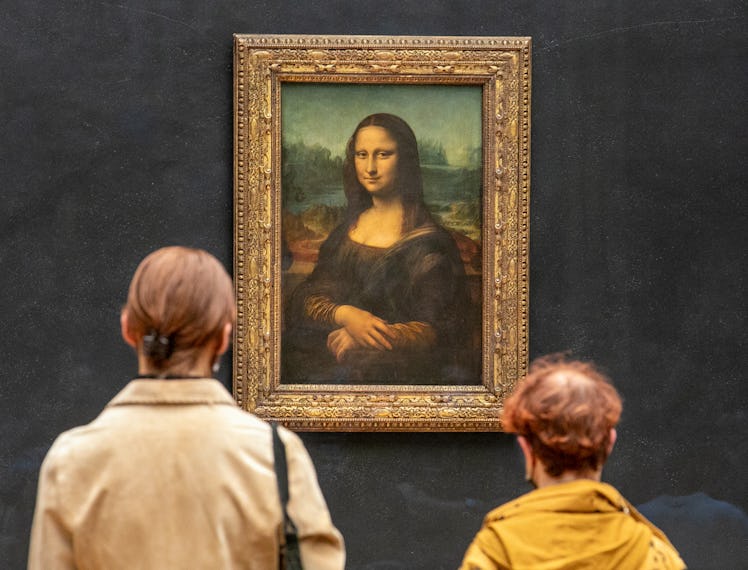 Visitors observe the painting 'La Joconde' The Mona Lisa by Italian artist Leonardo Da Vinci on disp...