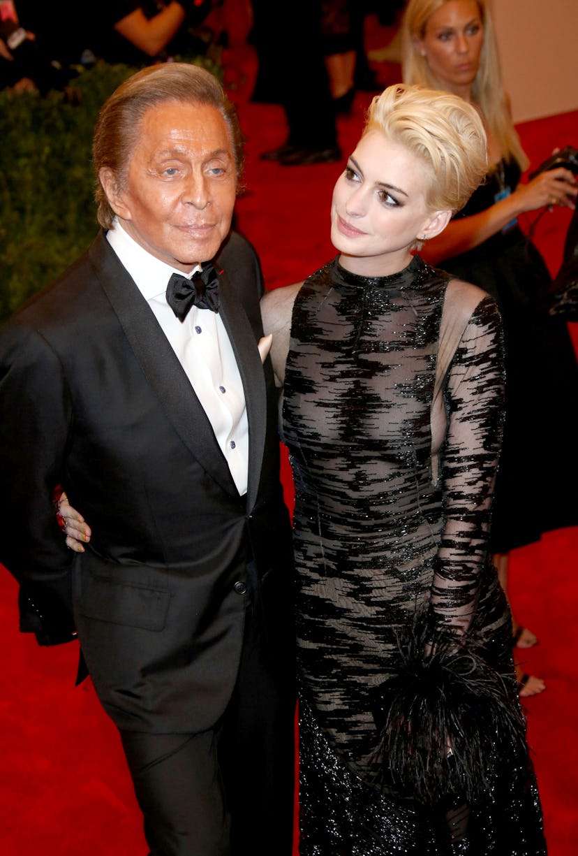 Actress Anne Hathaway and designer Valentino arrive at the Costume Institute Gala for the "Punk: Cha...