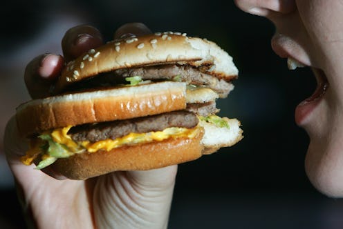 LONDON - JULY 12: In this photo illustration a lady eats a beefburger on July 12, 2007 in London, En...