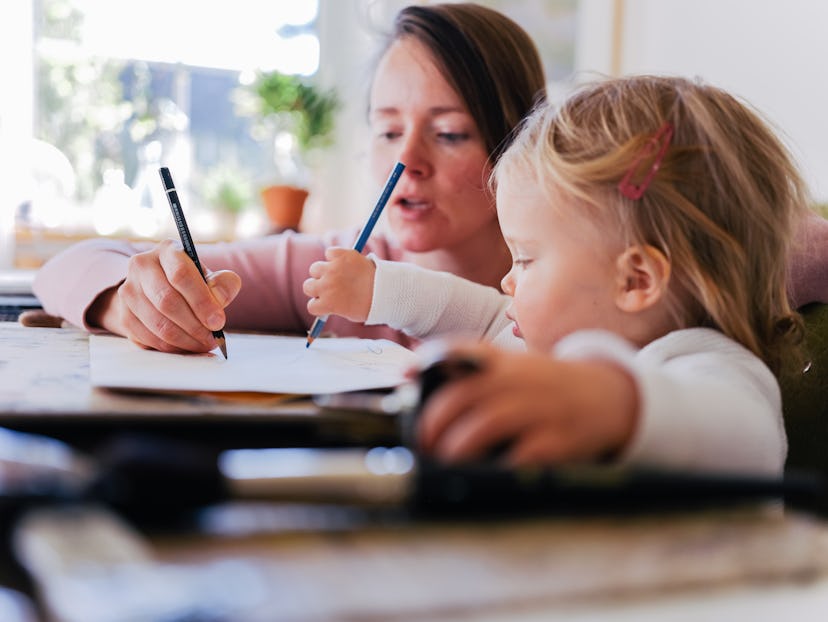 Mother and daughter drawing and writing together at home, in a list of powerful baby girl names.