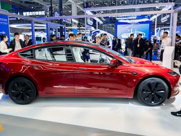 SHANGHAI, CHINA - NOVEMBER 06: People look at a Tesla Model 3 sedan at the Tesla booth during the si...