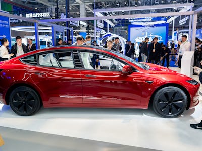 SHANGHAI, CHINA - NOVEMBER 06: People look at a Tesla Model 3 sedan at the Tesla booth during the si...