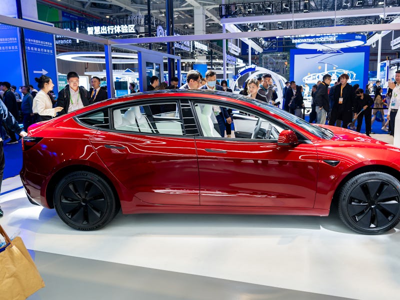 SHANGHAI, CHINA - NOVEMBER 06: People look at a Tesla Model 3 sedan at the Tesla booth during the si...