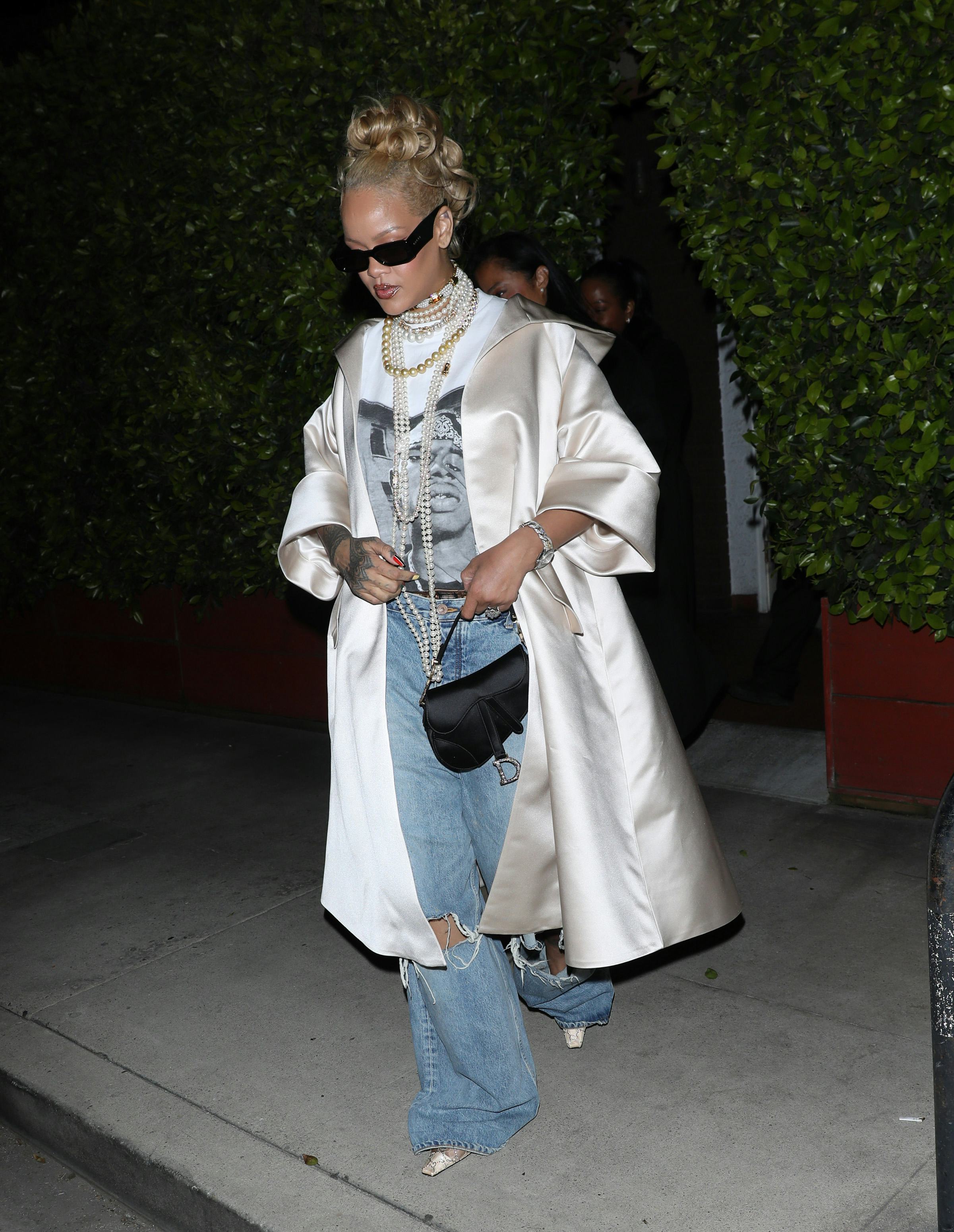 Rihanna wears a shirt, jeans, and satin coat at Giorgio Baldi restaurant on April 07, 2024.