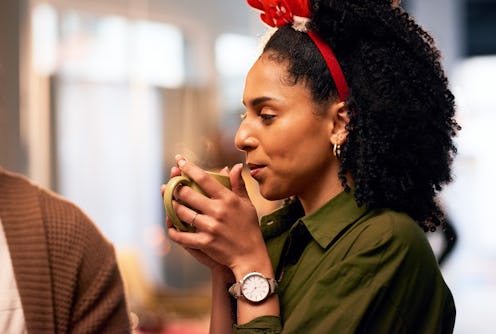 Christmas, woman drink coffee or tea with friends at dinner celebration or festive holiday at home. ...
