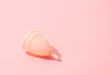 Menstrual cup on pink background. Periods, eco alternative, reusable replacement. Harsh light