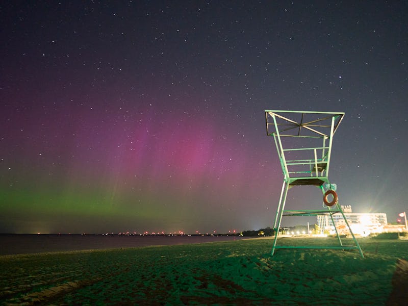 The Northern lights or aurora borealis illuminate the night sky at the beach in Grand Bend, Ontario,...