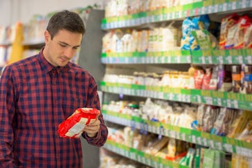 Man choosing snacks in supermarket