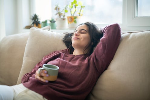 Young woman relaxing at home having a cup of coffee.