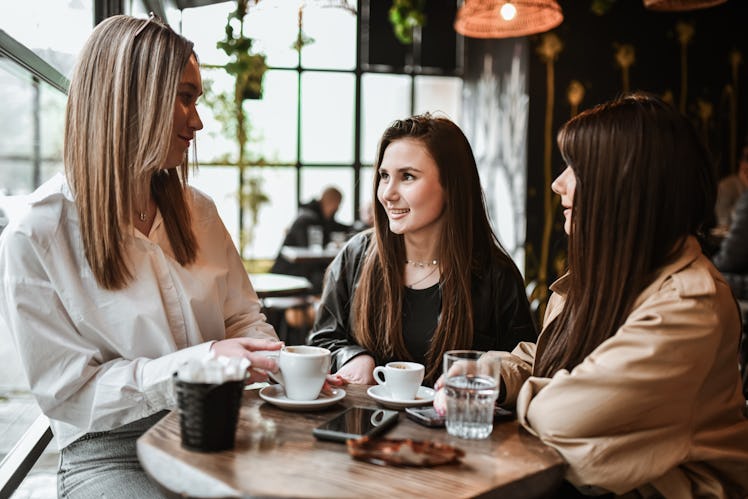 Three friends discussing the best and worst pickup lines women have heard in real life at a coffee s...