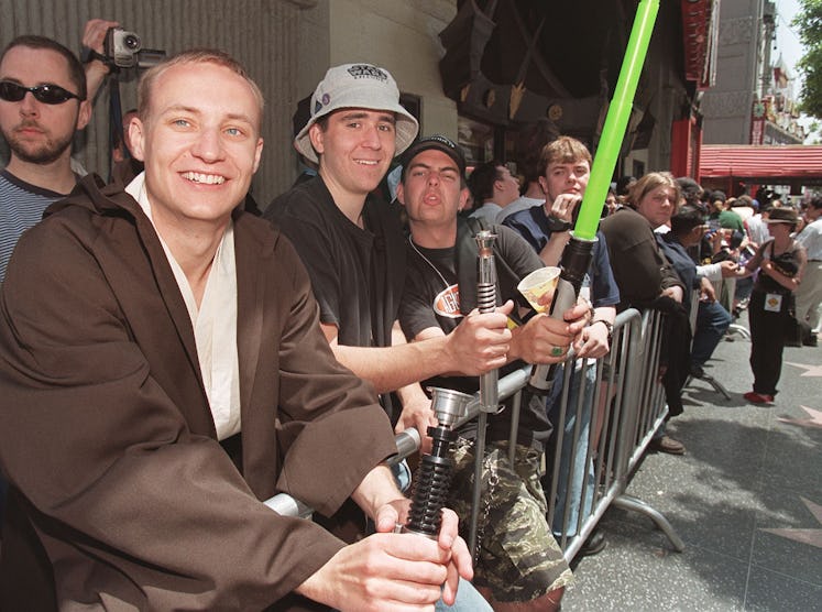 Star Wars fans hold their homemade lightsabers as they wait in line outside Mann's Chinese Theatre i...