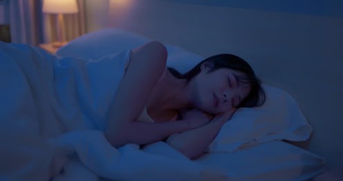 Closeup side view asian woman sleep deeply at night on the bed in dark bedroom