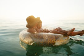 Photo of a young boy and his mother, relaxing and cooling off in the ocean on a hot summer afternoon...