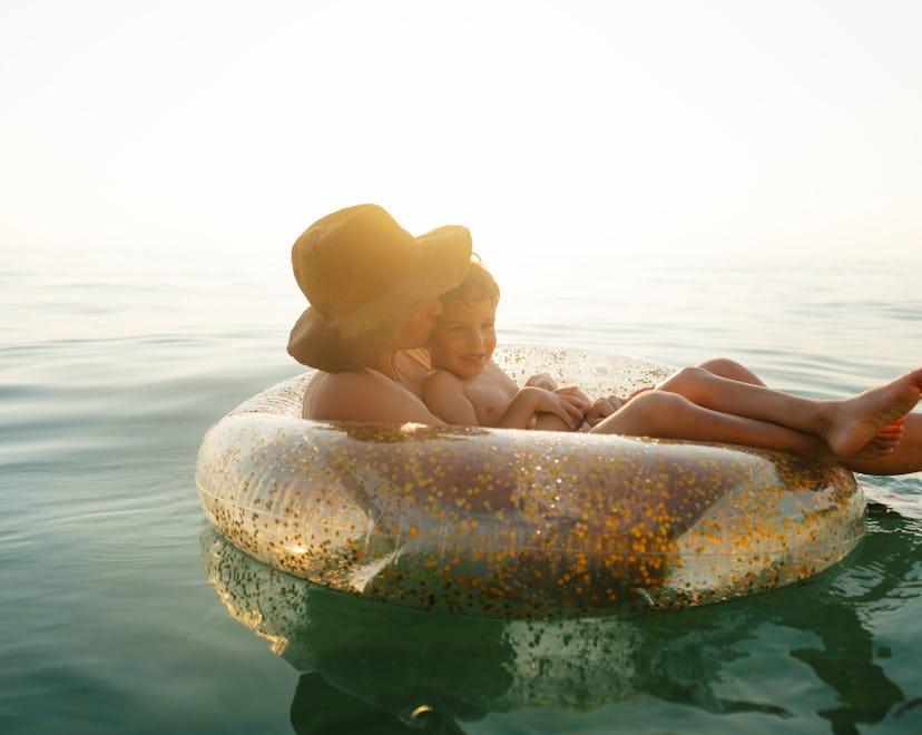 Photo of a young boy and his mother, relaxing and cooling off in the ocean on a hot summer afternoon...