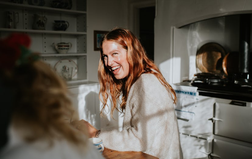 Woman laughing at her own Dad joke in the living room