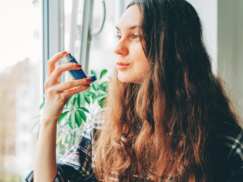 Young woman using an asthma inhaler