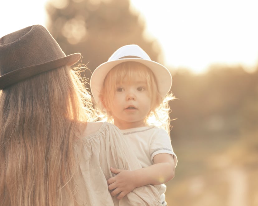 Young mother and her little boy walking in a park.