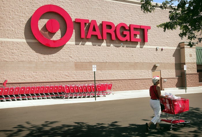 A shopper leaves a target store. Target is reducing its prices on roughly 5,000 items, including gro...