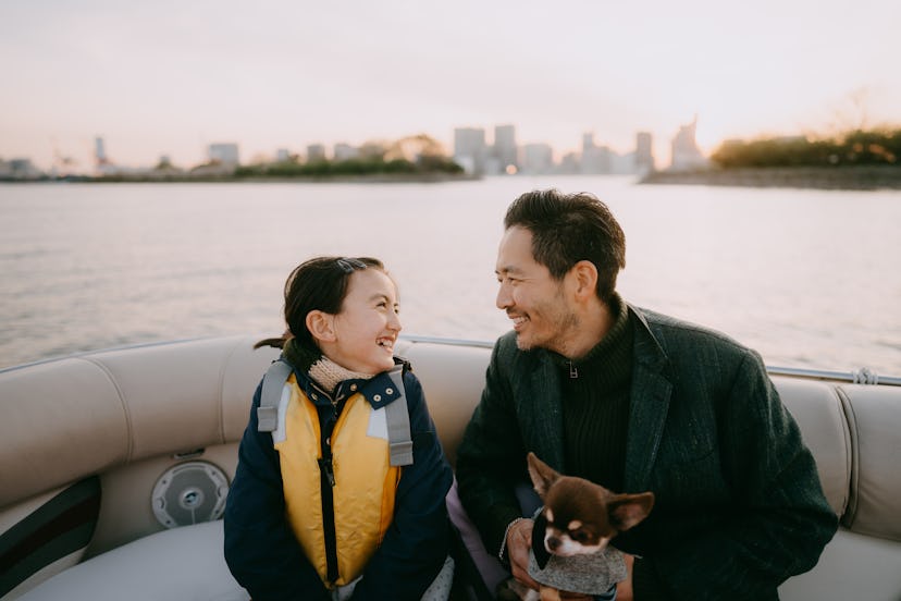 A dad telling his daughter some dad jokes for kids on a boat