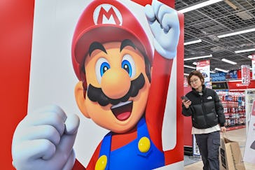 This photo taken on January 12, 2024 shows a customer walking past a display for Super Mario by the ...