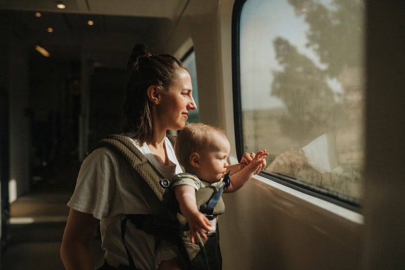 A mother who used place-inspired girl names to name her baby looks out a train window with her daugh...