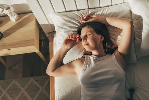 Feeling calmness. Sleepy female keeping eyes closed while dreaming about future vacation or sleeping...