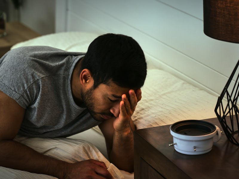 Depression, headache and man in a bed frustrated by insomnia, anxiety or sleep paralysis. Fatigue, c...