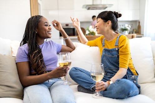 Group of friends man and woman, having great fun together, talking and smiling while tasting wine.