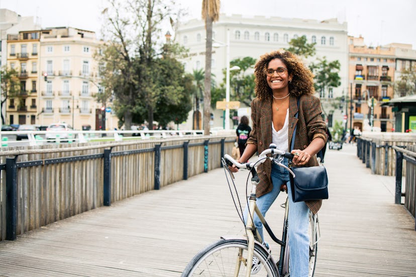 Beautiful Latin American woman with a bicycle enjoying her vacation in Valencia.