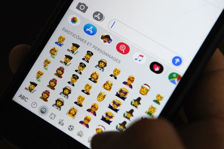 TOPSHOT - A person holds an iPhone showing emojis in Hong Kong, on October 30, 2019. - Apple has put...