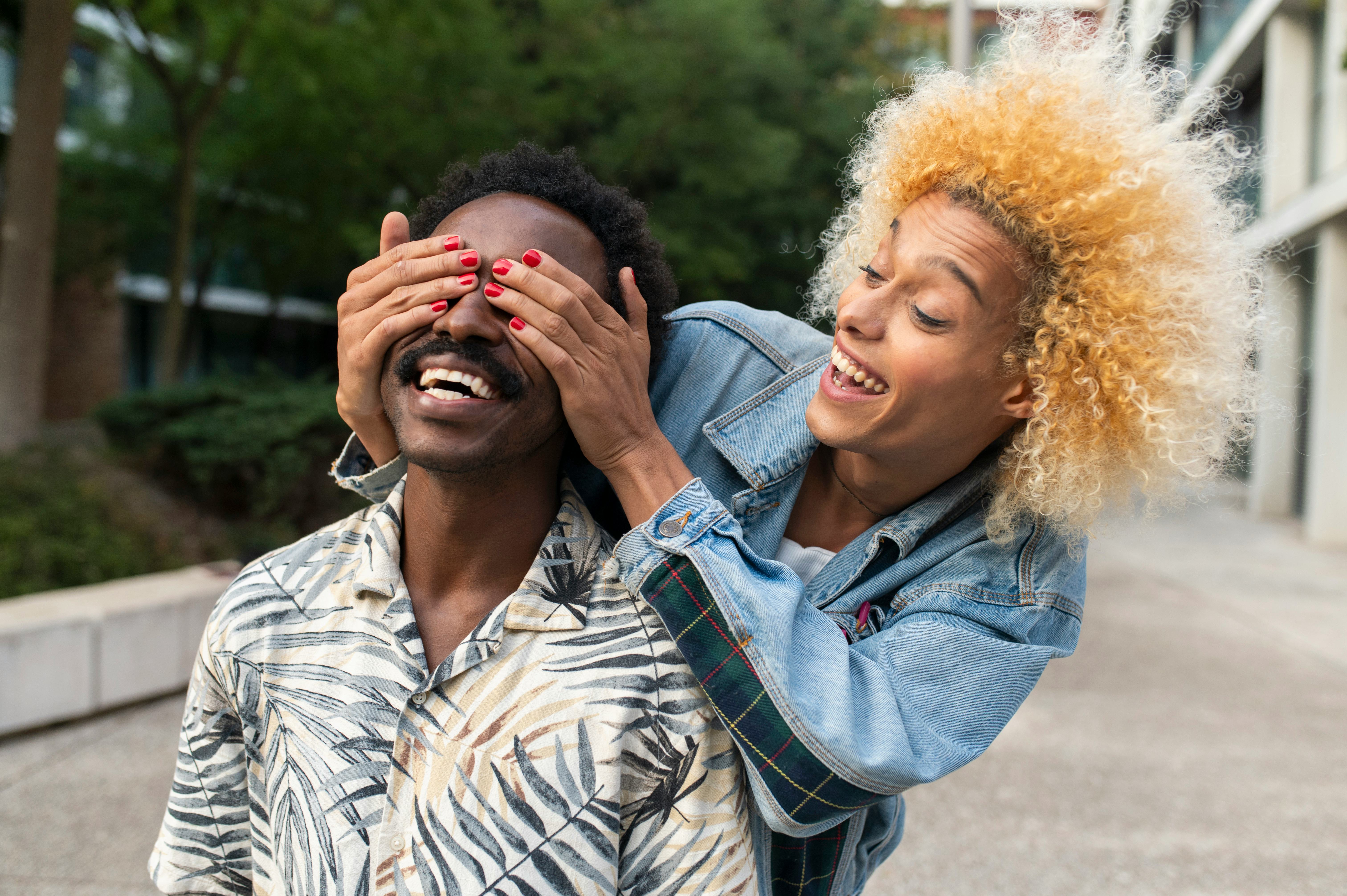 A woman smiling and surprising a smiling man with some good jokes as pickup lines