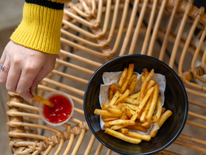 french fries in Black bowl on the rattan wooden table