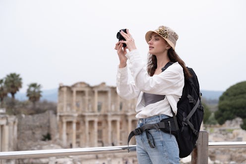 Portrait of young tourist woman in a historical archeological ancient town ruins.