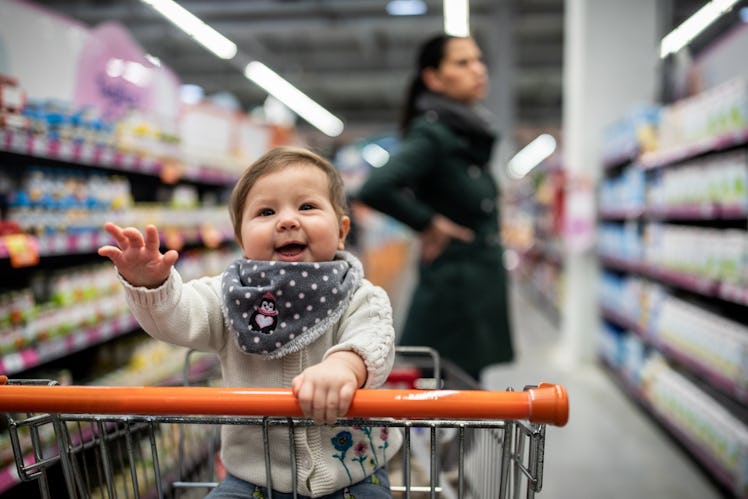 Mother and baby daughter at the supermarket doing shopping together