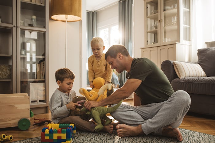 Young dad playing with his two little sons as they create a Father's Day scavenger hunt for him.