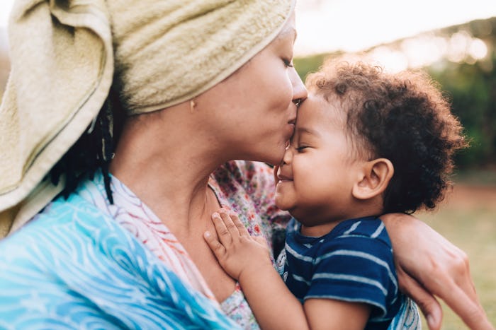 A mother kissing the forehead of her baby with a soft and gentle word name.