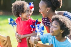 An African American mother with two mixed race children celebrating an American patriotic holiday, p...