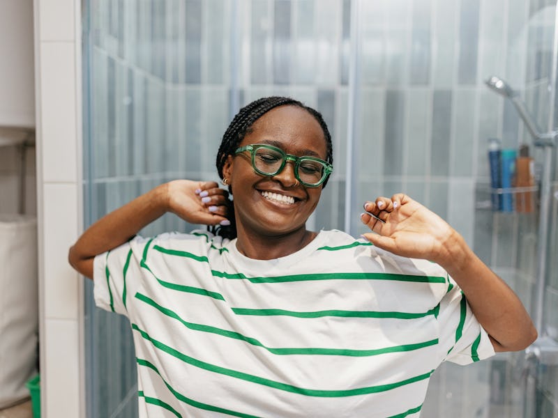 One young black woman stretching in her bathroom